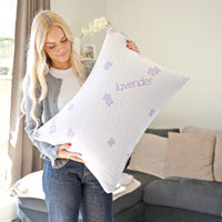 Kvinde holder Hushly PerfectPillow kølende pude i et lyst soveværelse